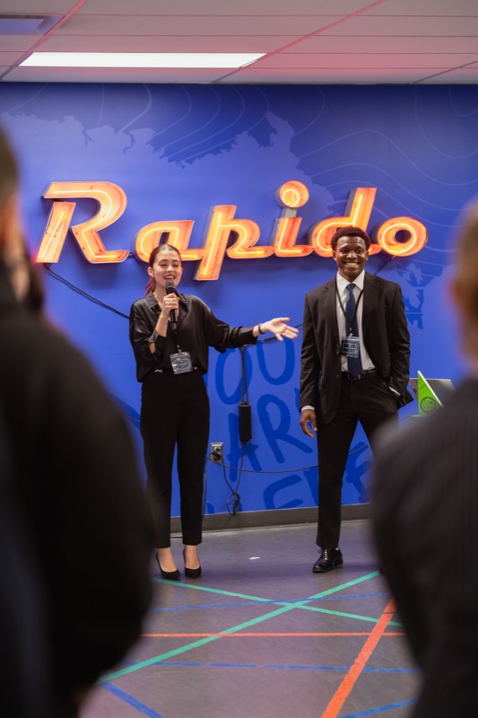 Co-presidents welcoming guests under the Rapido sign